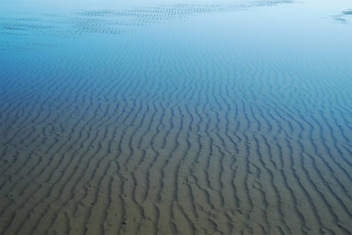 Photo of a shallow ocean pool with sand ripples